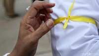 Pita kuning diikatkan di lengan.