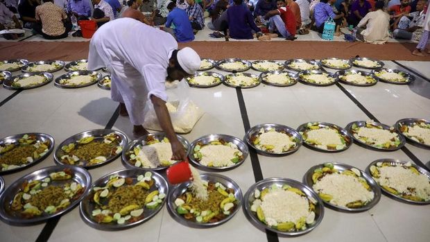 A volunteer arranges food plates at the Baitul Mokarram national mosque for the muslims to break fast during the fasting month of Ramadan in Dhaka, Bangladesh, May 8, 2019. REUTERS/Mohammad Ponir Hossain