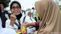 Sebagian peserta mengikatkan pita kuning di pergelangan tangan.