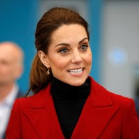 Gaya ibu tiga anak ini semakin chic dengan padanan tas tangan kulit nan classy dan suede ankle boots hitam. Kate lalu menjaga penampilannya dengan hair-do bergaya kuncir sederhana. Foto: Getty Images