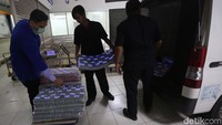 Petugas memasukan uang ke mobil untuk didistribusikan ke kantor cabang.