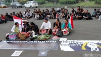 Massa aksi Kamisan membentangkan spanduk di depan Istana Merdeka, Jakarta.