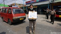Petugas nampak membawa barang yang diamankan dari toko ponsel tersebut selama berlangsungnya penggeledahan.
