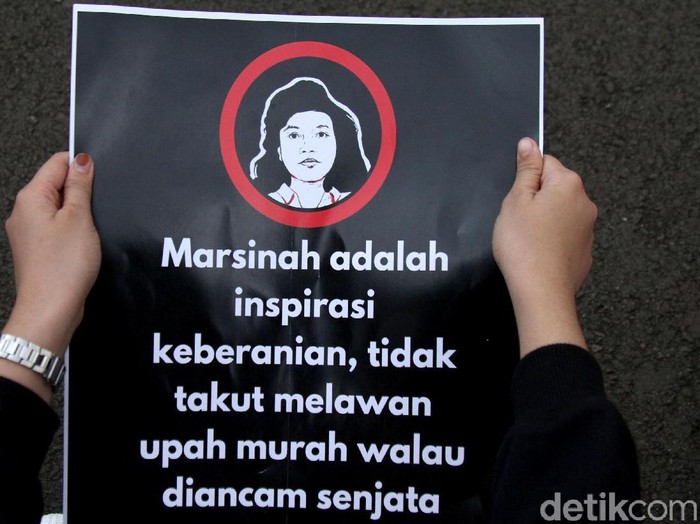 Massa aksi Kamisan membawa poster serta spanduk di depan Istana Merdeka. Kamisan kali ini memperingati 26 tahun kasus Marsinah.