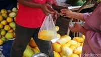 Seorang pedagang timun suri melayani pembeli di pasar pal merah Jakarta.