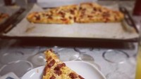 Ini jadi bukti kalau Alan Walker suka dengan pizza. Mulai dari order hingga menikmati sepotong pizza bertabur keju gurih. Foto: Instagram@alanwalkermusic