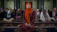 Yonghua Zheng (Kerudung Oranye) jadi salah satu imam perempuan yang ada di Qinyang City, Provinsi Henan, China. Sosok muslimah yang memimpin salat jemaah muslimah di sebuah masjid khusus perempuan di kota itu pun bukan lagi menjadi pemandangan yang aneh di China. Kevin Frayer/Getty Images.