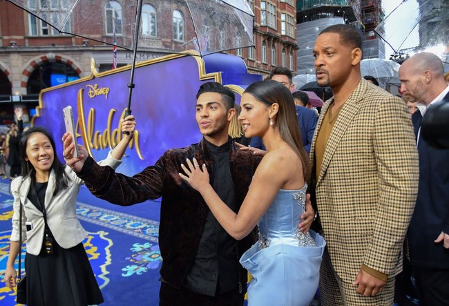 Turut hadir di premier tersebut, Mena Massoud yang memerankan Aladdin. Tidak ketinggalan, sang pemeran Genie, aktor Will Smith. Begini aksi mereka ketika selfie bersama. Foto: Getty Images