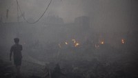 Warga berjalan di sekitar lokasi kebakaran di Kampung Bandan, Jakarta Utara, Sabtu (11/5/2019).