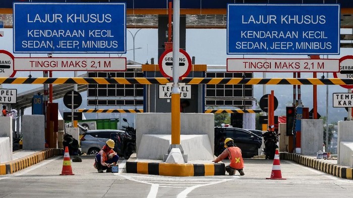 Petugas mengecat area gerbang tol Singosari yang belum beroperasi di Malang, Jawa Timur, Minggu (12/5/2019). Ruas Tol Pandaan-Malang seksi I-III dari Pandaan-Singosari sepanjang 31 Km itu diharapkan akan memperlancar arus mudik Lebaran 2019 di Jawa Timur. ANTARA FOTO/Rivan Awal Lingga/ama.