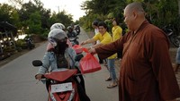 Sejumlah umat Buddha membagikan makanan untuk berbuka puasa kepada para pengendara yang melintas di depan gedung Pusat Pelatihan Meditasi Arama Maha Buddha, Makassar, Sulawesi Selatan. Antara Foto/Abriawan Abhe.
