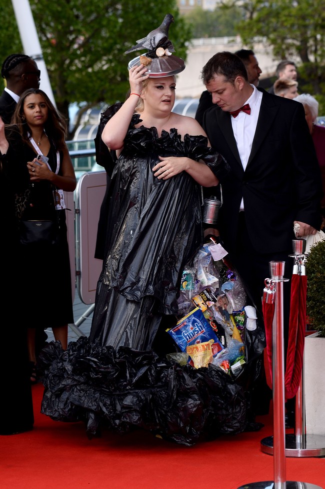 Kantong plastik sampah berwarna hitam menjadi material utama gaun bersiluet A-line tersebut. Terdapat detail ruffle yang menghiasi area bahu gaun bergaya off-shoulder dan rok sehingga tetap menyumbangkan kesan anggun. (Foto: Getty Images)