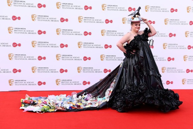 Menariknya, gaun pilihan aktris serial This Country di BBC itu dilengkapi dengan ekor yang penuh sampah rumah tangga. Tampak bungkusan odol, sereal, sampai potongan sayuran ikut mempermanis gaya Daisy. (Foto: Getty Images)