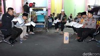 Warga dan polisi makan lesehan. Berbekal tikar dan kursi seadanya, mereka santap sahur di bahu jalan.