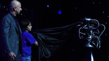 Bezos dibantu seorang anak untuk memamerkan mesin BE-7 yang akan digunakan oleh Blue Moon. Foto: Reuters/Clodagh Kilcoyne