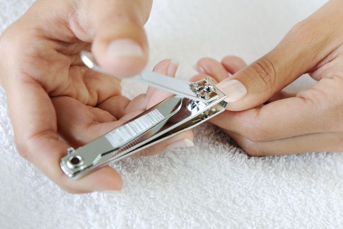 Nail technician clipping customers nails at the nail salon