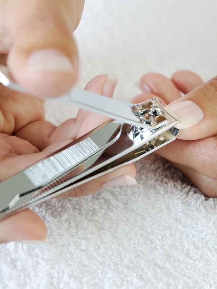 Nail technician clipping customers nails at the nail salon