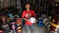 Seorang penjual menunjukkan rebana yang dijual di salah satu toko di Jalan Ekor Kuning, Penjaringan, Jakarta Utara.