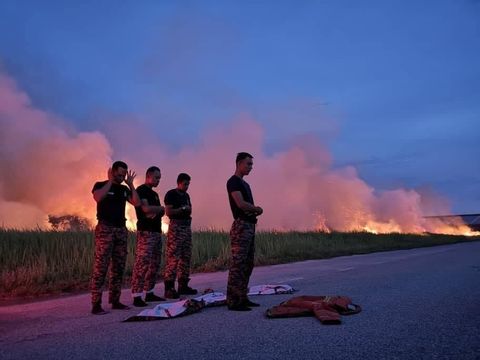 Para petugas pemadam kebakaran Malaysia juga salat berjamaah di jalanan usai menjalankan tugasnya