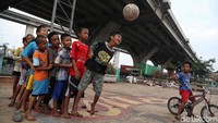 Sejumlah anak bermain bola di bawah kolong tol Tanjung Priok, Jakarta Utara, Senin (13/5).
