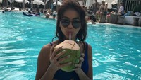 Masih dalam suasana liburan, model cantik berusia 27 tahun ini terlihat asyik melepas dahaga dengan es kelapa segar setelah berenang. Foto: Instagram @bungajelitha66