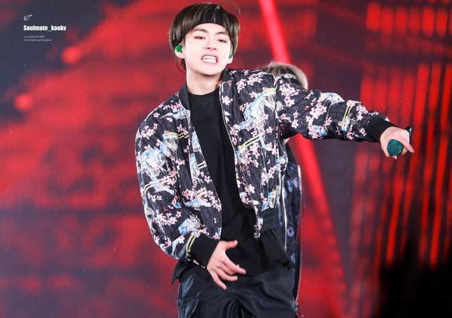 V BTS bisa membuat jaket bomber kembali tren. Ia pun menggabungkan luaran bermotif floral tersebut dengan celana kargo hingga sepatu boots. Foto: Istimewa