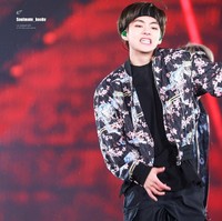 V BTS bisa membuat jaket bomber kembali tren. Ia pun menggabungkan luaran bermotif floral tersebut dengan celana kargo hingga sepatu boots. Foto: Istimewa