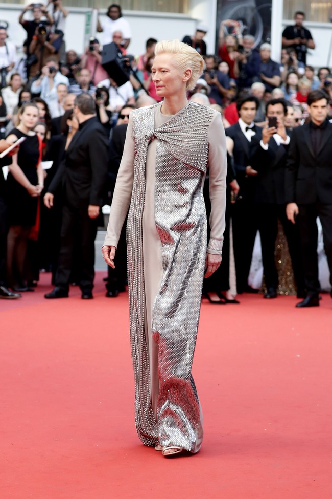 Tilda Swinton tampil futuristik untuk ajang ini. Mengenakan gaun abu-abu dengan ornamen sequin perak di sepanjang gaun. Foto: Getty Images