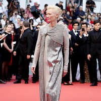 Tilda Swinton tampil futuristik untuk ajang ini. Mengenakan gaun abu-abu dengan ornamen sequin perak di sepanjang gaun. Foto: Getty Images