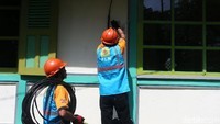 Dua petugas tengah memasang token listrik 900 VA untuk rumah warga di Jalan Pangalengan, Lamajan desa Tribakti Mulya, Bandung, Jawa Barat