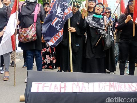 Massa membawa keranda dalam aksi itu.