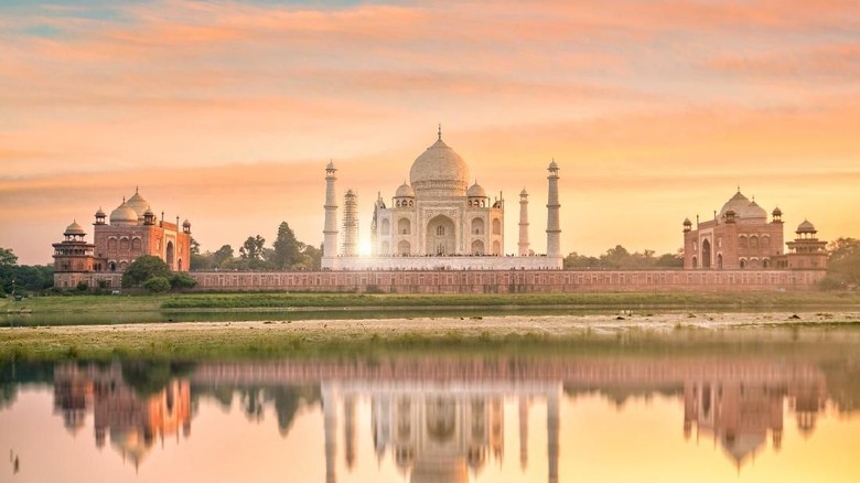 Masjid Jawab di Agra Agra, India - September 21, 2015: Muslim tourists posing for a photograph in one of the two grand red sandstone buildings that mirror each other, and face the sides of the tomb of Taj Mahal Agra India This one is a mosque