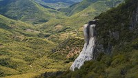 Biasanya air terjun mengalir dengan deras dari pegunungan. Namun air terjun di Meksiko ini tidak. Bukan air, namun bebatuan mineral seperti air terjun membeku yang menjuntai di tebing. (iStock)