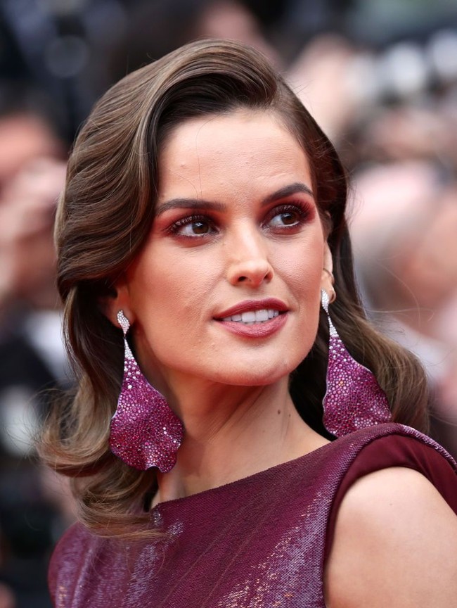 Sebagai sentuhan akhir, Izabel mempermanis gayanya dengan anting unik berbentuk kelopak bunga anggrek dari Chopard. (Foto: Getty Images)