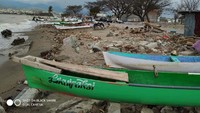 Perahu nelayan bersandar di puing-puing sisa gempa. (Istimewa)