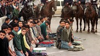 Sejumlah anak muda Palestina menjalankan salat jumat ketiga di bulan suci Ramadhan di area sekitar Masjid Al-Aqsa dengan penjagaan ketat dari sejumlah polisi Israel. David Silverman/Newsmakers.
