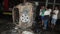 Warga melihat bangkai mobil yang rusak dampak kerusuhan di Lapas Narkotika Kelas III Langkat, di Langkat, Sumatera Utara, Kamis (16/5/2019). ANTARA FOTO/Irsan Mulyadi.
