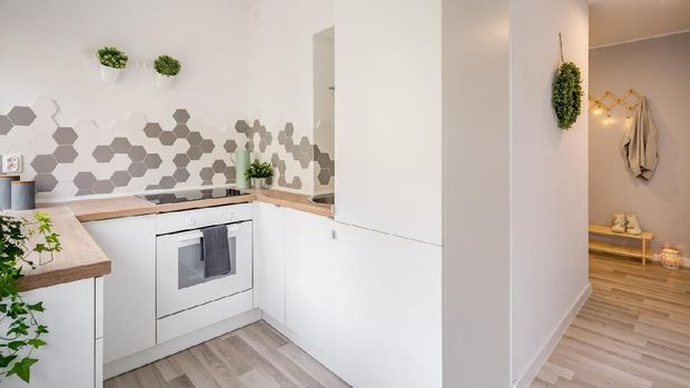 Cozy apartment with small, white kitchen and gray mudroom