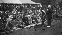 Foto ini diambil pada tahun 1930-an saat umat Muslim mendengarkan khotbah di pelaksanaan salat Idul Fitri di halaman Masjid Shah Jahan, Woking, Inggris. J. A. Hampton/Topical Press Agency/Hulton Archive/Getty Images.