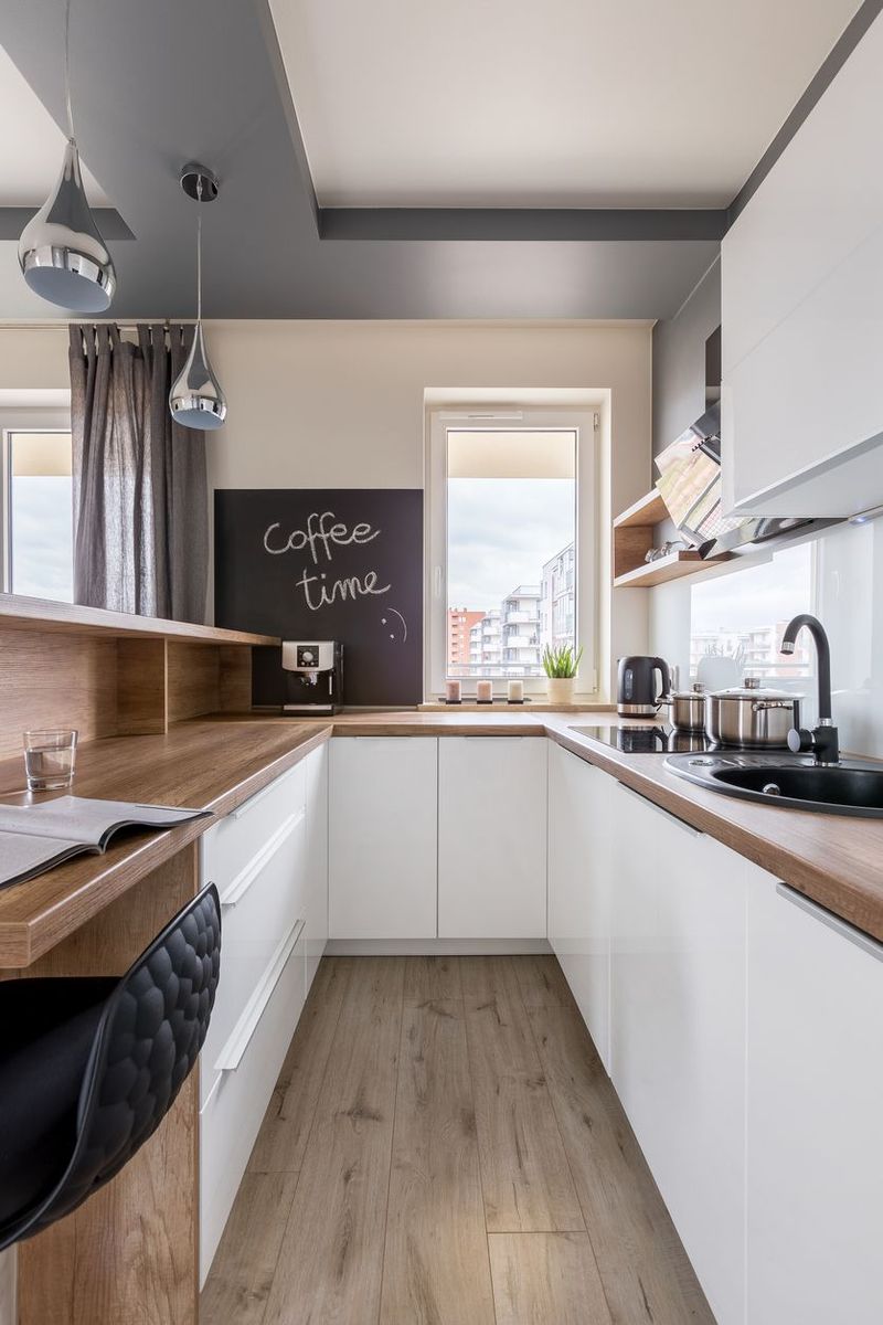 Modern kitchen with wooden worktop, white unit and blackboard
