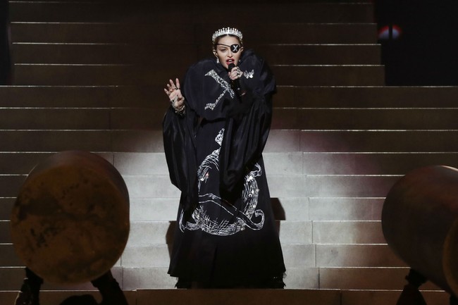 Dalam aksi panggungnya, Madonna terlihat memakai jubah hitam dengan penutup mata ala bajak laut yang dihiasi huruf X. Jubah tersebut membungkus mini-dress dan boots tinggi berbahan kulit. Adalah stylist bernama Eyob Yohannes yang berada di balik gaya tersebut.  Foto: Dok. Getty Images
