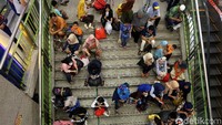 Sejumlah warga beristirahat di tangga setelah lelah berkeliling untuk mencari kebutuhan lebaran.