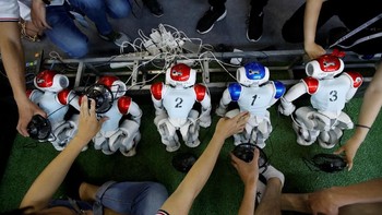Para robot berbaris untuk diisi ulang dayanya saat jeda laga. (Foto: Jason Lee/Reuters)