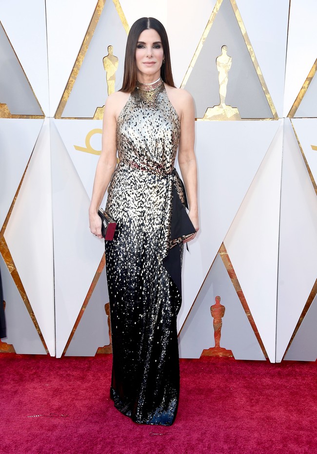 Cantik dan bersahaja, Sandra Bullock tampil dengan gaun halterneck Louis Vuitton yang tampil mewah dengan sequin emas. Foto: Dok. Getty Images
