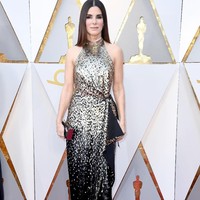 Cantik dan bersahaja, Sandra Bullock tampil dengan gaun halterneck Louis Vuitton yang tampil mewah dengan sequin emas. Foto: Dok. Getty Images