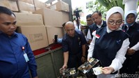 Kepala BPOM Penny Kusumastuti Lukito membongkar kardus berisi produk kadaluarsa.