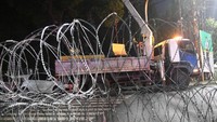 Petugas Dinas Perhubungan memindahkan pembatas jalan menggunakan alat berat di depan kantor KPU, Jakarta, Senin (20/5/2019). ANTARA FOTO/Akbar Nugroho Gumay.
