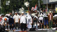 Setelah itu, massa kembali ke tengah jalan untuk salat. Mereka membuat saf dan menggunakan kain serta baliho jadi alas.
