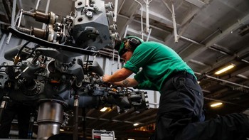Tampak mekanik sedang memasang komponen di helikopter MH-60R Sea Hawk. Foto: Reuters