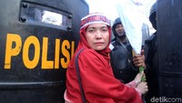 Polisi yang tengah menjaga aksi mereka dengan senang hati menerima bunga tersebut.